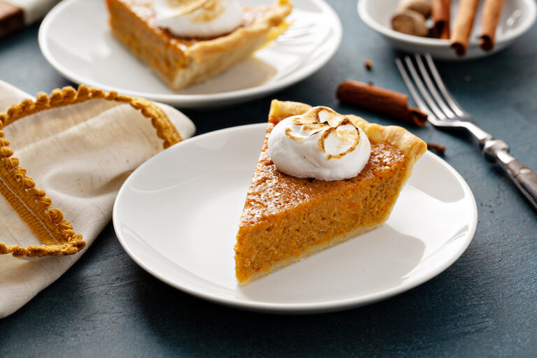 Sweet potato put on a white plate topped with whipped cream.