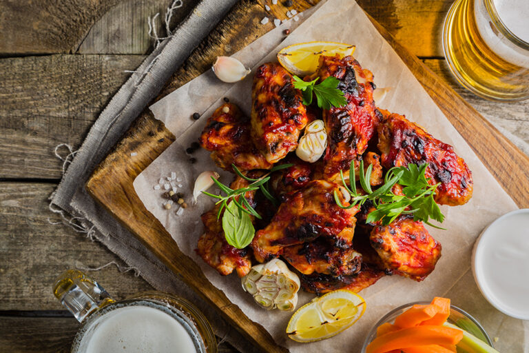 Jerk chicken with garnish on a wooden cutting board