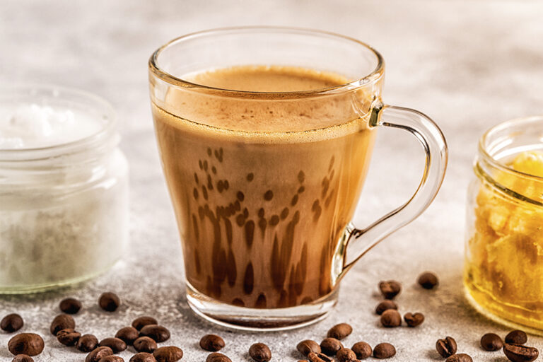 Une tasse en verre transparent remplie de café à l'huile d'olive.